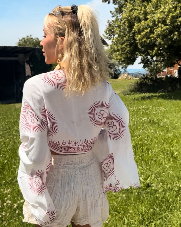 Weisse Boho Baumwolle Wickel Bluse mit weiten Fledermausaermel und roten Om Zeichen 